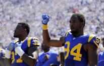 <p>Los Angeles Rams defensive end Robert Quinn, right, gestures during the national anthem prior to an NFL football game against the Seattle Seahawks at Los Angeles Memorial Coliseum, Sunday, Sept. 18, 2016, in Los Angeles. (AP Photo/Jae Hong) </p>
