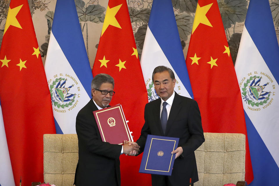 In this Tuesday, Aug. 21, 2018, file photo, El Salvador's Foreign Minister Carlos Castaneda, left, and China's Foreign Minister Wang Yi shake hands at a signing ceremony to mark the establishment of diplomatic relations between the two countries at the Diaoyutai State Guesthouse in Beijing. Taiwan broke off diplomatic ties with El Salvador on Tuesday as the Central American country defected to rival Beijing in the latest blow to the self-ruled island China has been trying to isolate on the global stage. (AP Photo/Mark Schiefelbein, File)