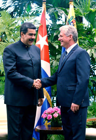 Cuban President Miguel Diaz-Canel (R) shakes hands with Venezuela's President Nicolas Maduro at the Revolution Palace in Havana, Cuba April 21, 2018. Ernesto Mastrascusa/Pool via Reuters