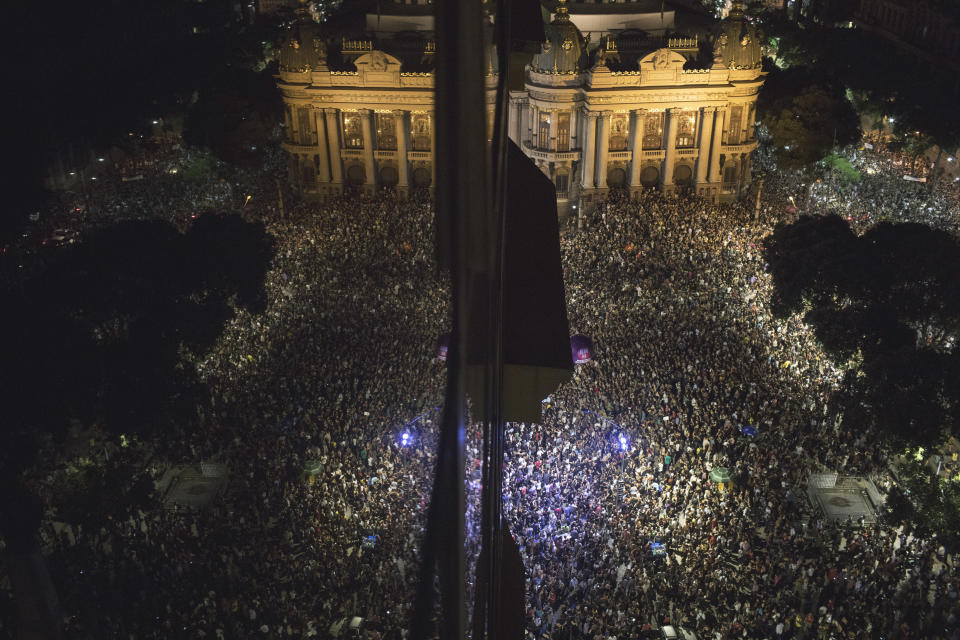 FILE - Thousands gather in front of the Municipal Theater in downtown Rio de Janeiro, during a protest against the death of councilwoman Marielle Franco, who was gunned down by two unidentified attackers, in Rio de Janeiro, Brazil, March 15, 2018. The 38-year-old stood out as one of the only Black, bisexual women in politics and the abrupt end of her rise shook Brazil with mass protests that echoed around the world. (AP Photo/Leo Correa, File)