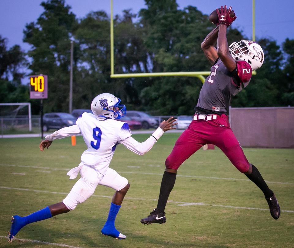 North Marion Colts' Elija Walton (2) hauls in a pass while being defended by Belleview's Kareem Walker (9). Walton scored a touchdown on the reception in the game Friday, Sept. 9, 2022.