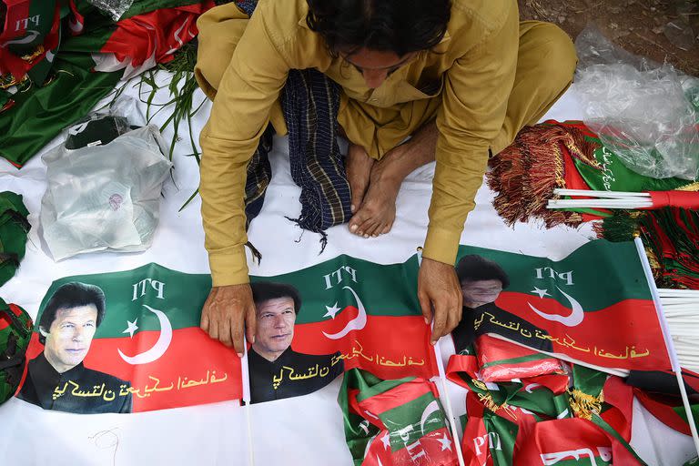 Un vendedor vende banderas del partido Pakistan Tehreek-e-Insaf (PTI) con la imagen del ex primer ministro de Pakistán, Imran Khan, frente a la residencia de Khan en Islamabad el 22 de agosto de 2022.