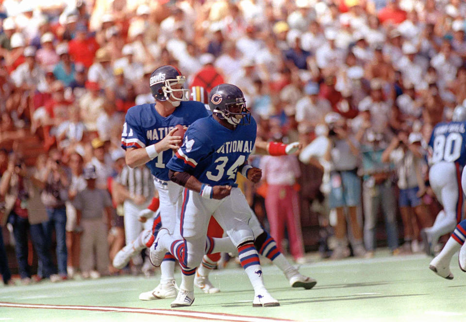 File-This 1986, file photo shows New York Giants quarterback Phil Simms (11) dropping back to pass while the Chicago Bears running back Walter Payton (34) gets set to block him during Pro Bowl Games in Hawaii. TV ratings for the Pro Bowl lag below all the prime time regular season games, and the on-field intensity and drama that fuels so much of the national interest in the sport is nonexistent. The annual all-star exhibition does not lack for history, however, with a genesis traced back to the 1938 season. (AP Photo/File)