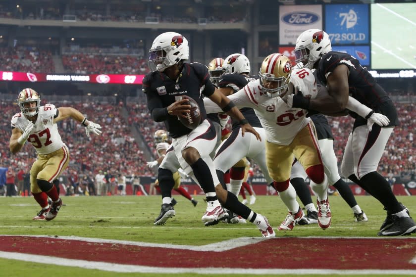 Arizona Cardinals quarterback Kyler Murray (1) eludes the reach of San Francisco 49ers defensive end Arik Armstead.