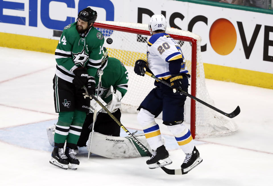 CORRECTS THAT THE SHOT WAS BY COLTON PARAYKO, NOT JADEN SCHWARTZ. - St. Louis Blues' Alexander Steen (20) watches as a shot by teammate Colton Parayko, not shown, slips past Dallas Stars' Jamie Benn (14) and hits Stars goaltender Ben Bishop during the third period in Game 6 of an NHL second-round hockey playoff series, Sunday, May 5, 2019, in Dallas. Bishop was injured on the play leading to a goal by the Blues' Jaden Schwartz. (AP Photo/Tony Gutierrez)