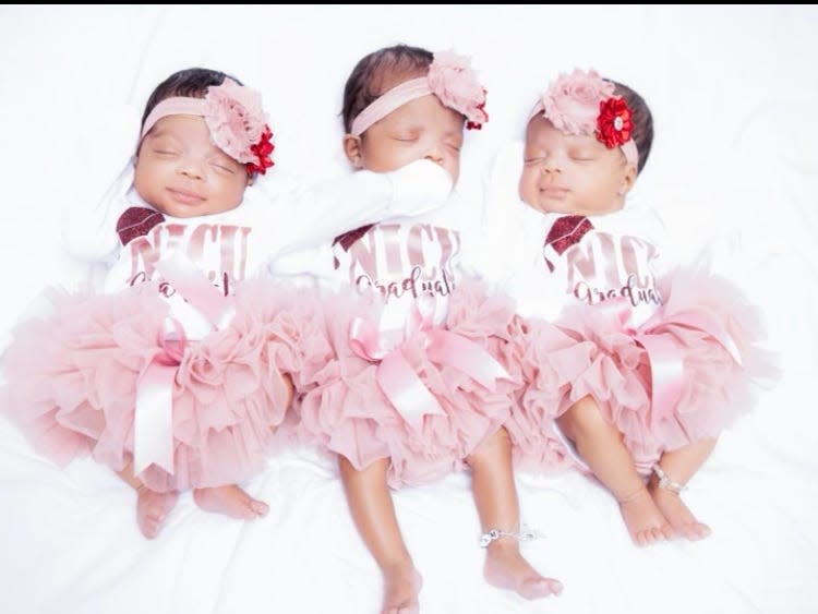 Three baby girls asleep wearing pink dresses