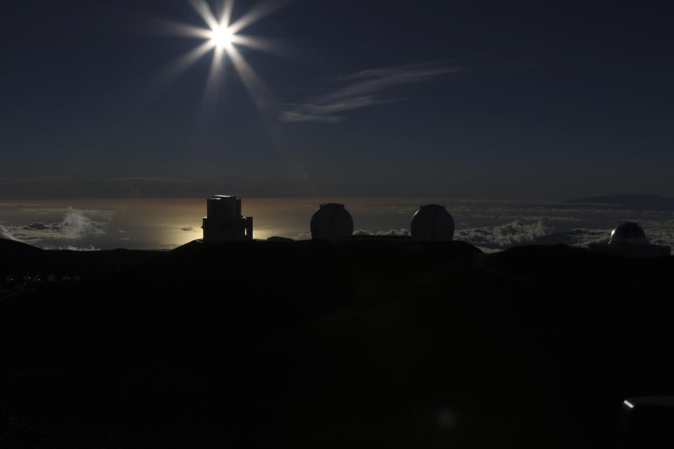 The sun sets behind telescope at the summit of Hawaii's Mauna Kea, Sunday, July 14, 2019. Hundreds of demonstrators are gathered at the base of Hawaii's tallest mountain to protest the construction of a giant telescope on land that some Native Hawaiians consider sacred. State and local officials will try to close the road to the summit of Mauna Kea Monday morning to allow trucks carrying construction equipment to make their way to the top. Officials say anyone breaking the law will be prosecuted. Protestors have blocked the roadway during previous attempts to begin construction and have been arrested. (AP Photo/Caleb Jones)
