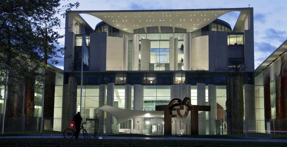 In this Monday, Nov. 16, 2020 photo the German Chancellery is illuminated in Berlin, Germany. German Chancellor Angela Merkel and the country's 16 state governors are expected Wednesday to extend a partial shutdown well into December, and discuss tightening some restrictions while allowing somewhat more generous rules for the Christmas period. (AP Photo/Michael Sohn)