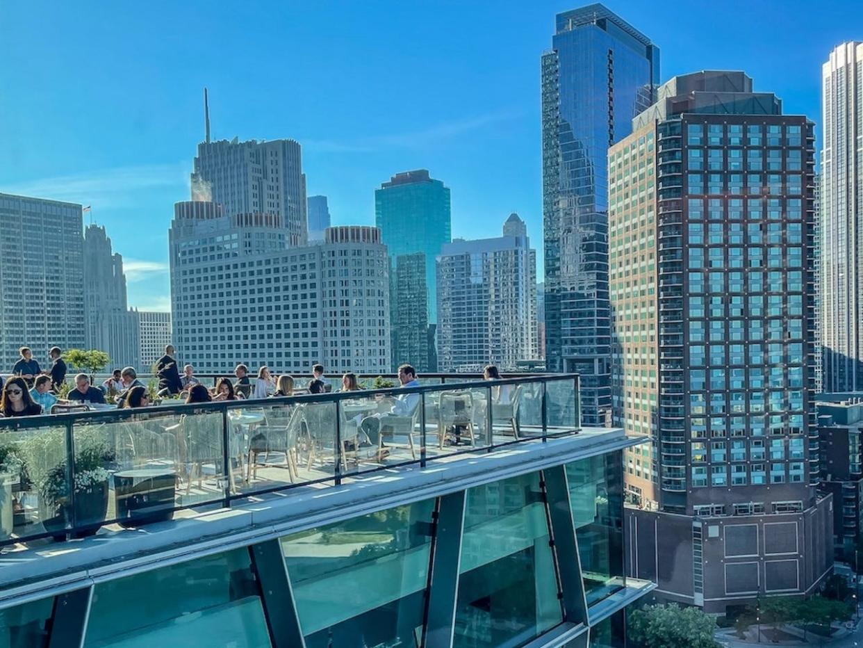 Diners sitting on the terrace of restaurant Miru looking over the Chicago River.