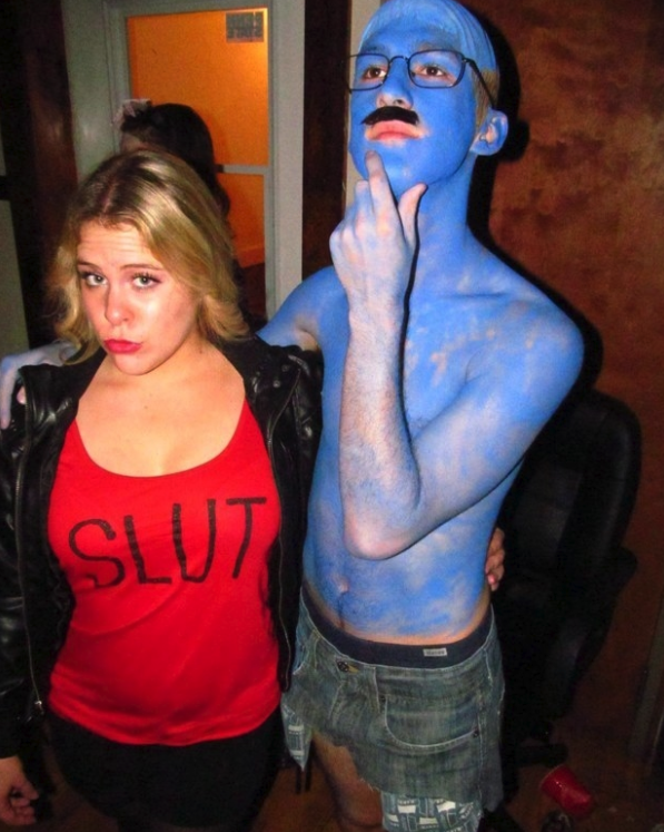 Someone dressed with blue paint on their body and another in a red shirt with "slut" written on it