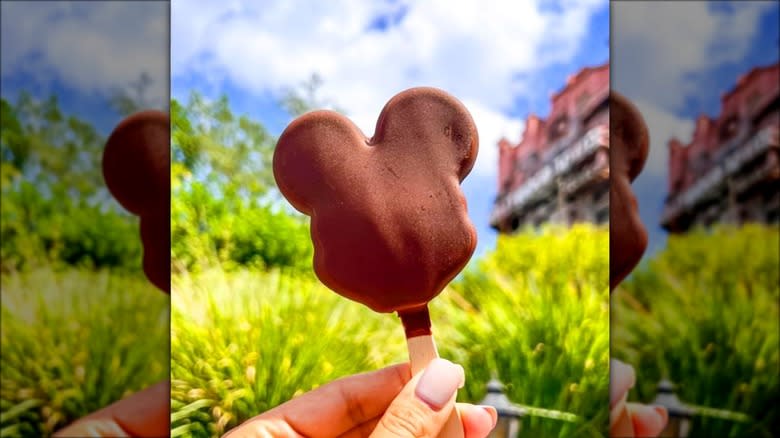 Hand holds Mickey Mouse chocolate ice cream