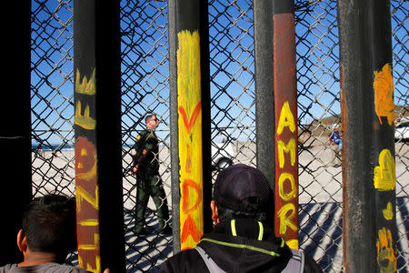 Migrants, part of a caravan of thousands trying to reach the U.S., look through the border fence between Mexico and the United States, in Tijuana, Mexico November 14, 2018. REUTERS/Jorge Duenes