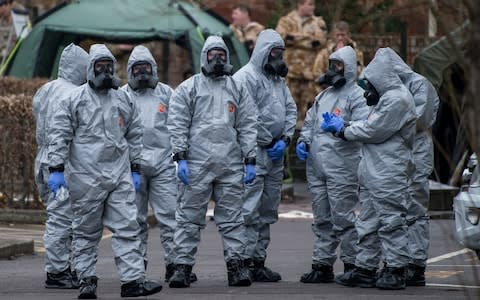 Military personnel wearing protective suits - Credit: Chris J Ratcliffe /Getty