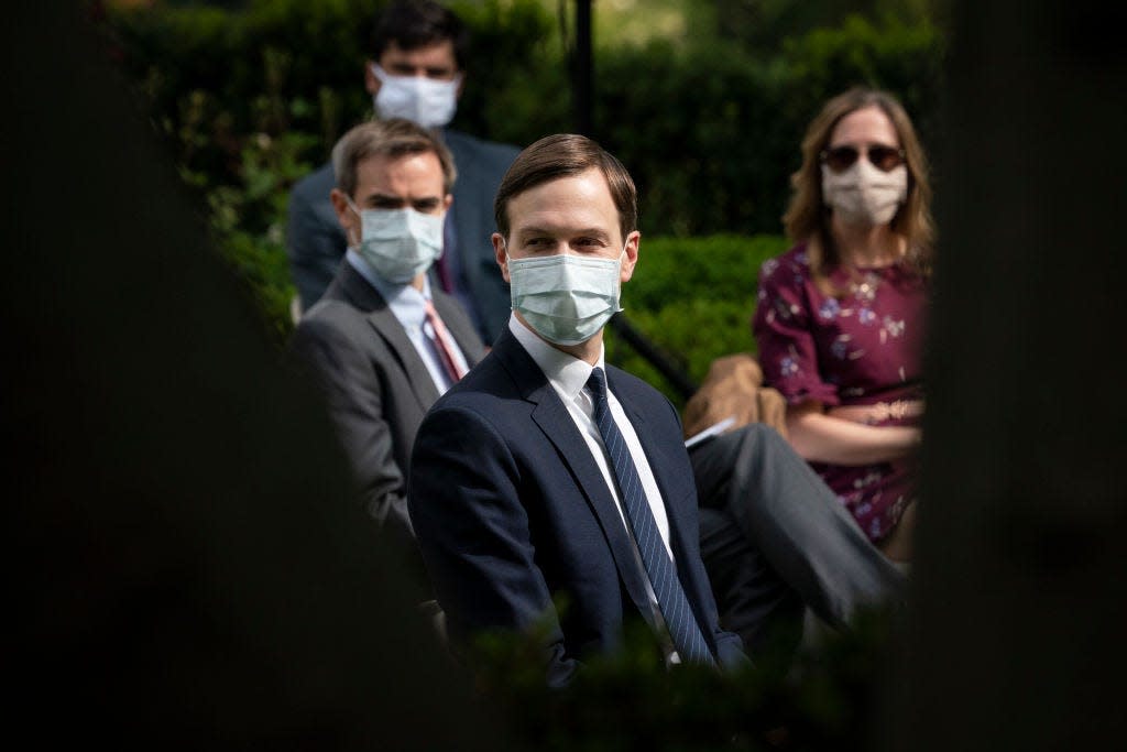 White House advisor Jared Kushner (center) and others wear face masks while attending a press briefing about coronavirus testing in the Rose Garden of the White House on May 11, 2020.