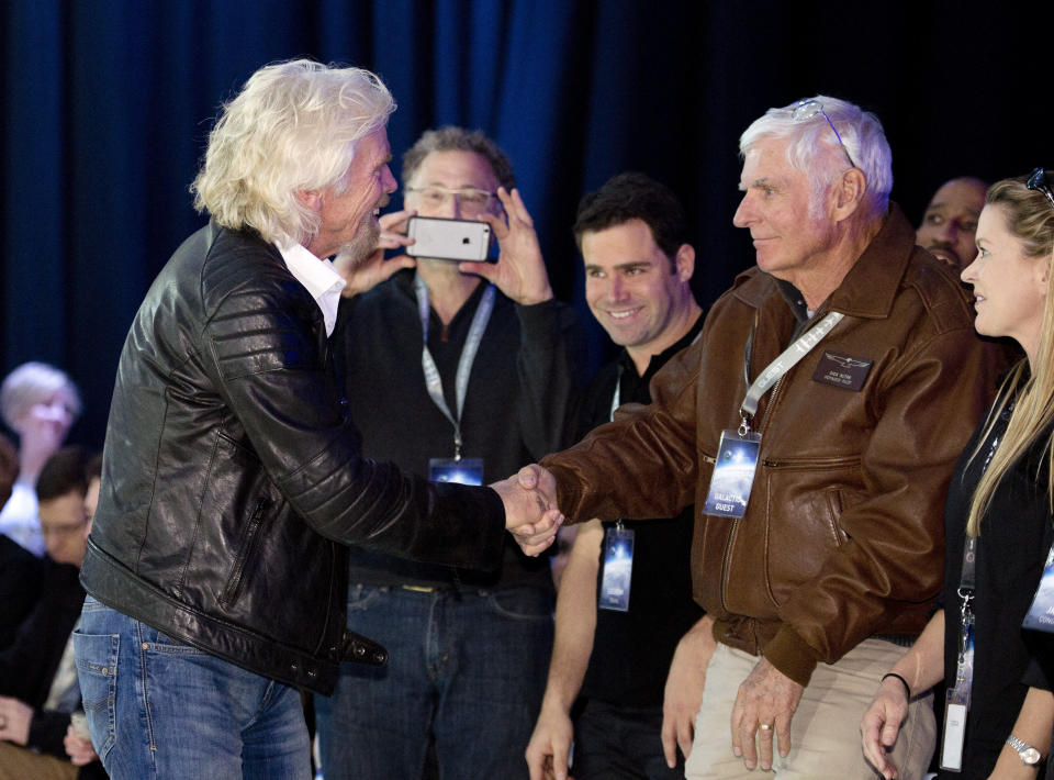 FILE - Sir Richard Branson, left, shakes hands with record breaking aviator Dick Rutan after Virgin Galactic's SpaceShipTwo space tourism rocket was unveiled, Friday, Feb. 19, 2016, in Mojave, Calif. Rutan, a decorated Vietnam War pilot, who along with copilot Jeana Yeager completed one of the greatest milestones in aviation history: the first round-the-world flight with no stops or refueling, died late Friday, May 3, 2024. He was 85. (AP Photo/Mark J. Terrill, File)