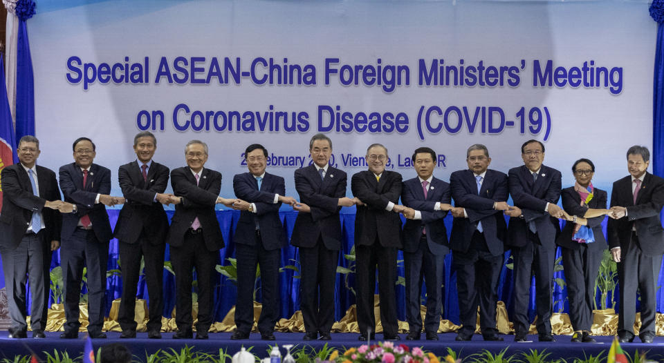 Chinese Foreign Minister Wang Yi, sixth from left, poses for a group photo with from left, Malaysian Foreign Minister Saifuddin Abdullah, Myanmar Minister of State for Foreign Affaires Kyaw Tin, Singapore's Foreign Minister Vivian Balakrishnan, Thailand's Foreign Minister Don Pramudwinai, Vietnamese Foreign Minister Pham Binh Minh, Philippines Foreign Affaires Secretary Teodoro Locsin Jr., Laos Foreign Minister Saleumxay Kommasith, Brunei Second Minister of Foreign Affairs and Trade Erywan Yusof, Cambodian Foreign Minister Prak Sokhon, Indonesian Foreign Minister Retno Marsudi, and ASEAN Secretary General Dato Lim Jock Hoi ahead of the Special ASEAN-China Foreign Ministers' meeting on the Novel Coronavirus Pneumonia in Vientiane, Laos, Thursday, Feb. 20, 2020. (AP Photo/Sakchai Lalit)