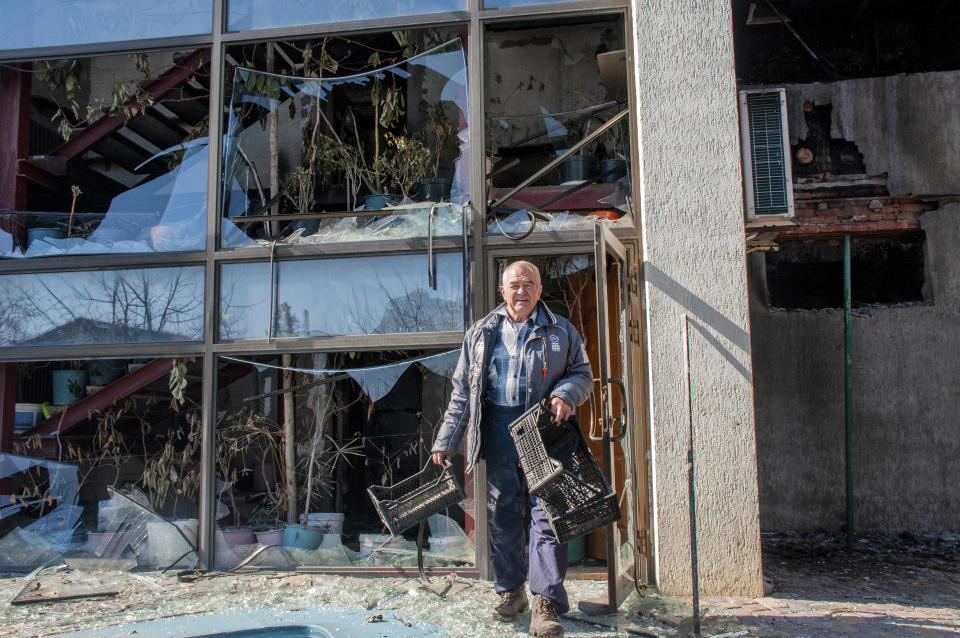 A man walks next to an apartments building hit by shelling in Kharkiv, Ukraine, Sunday, March 20, 2022. (AP Photo/Andrew Marienko)