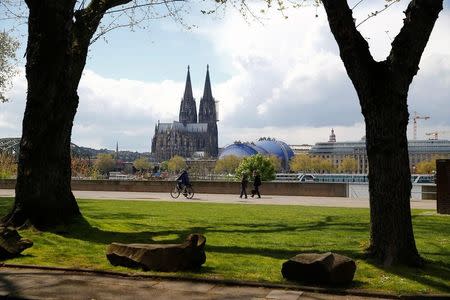 FILE PHOTO: People stroll through a park near the UNESCO world heritage the Cologne Cathedral in Cologne, Germany, April 28, 2016. REUTERS/Wolfgang Rattay