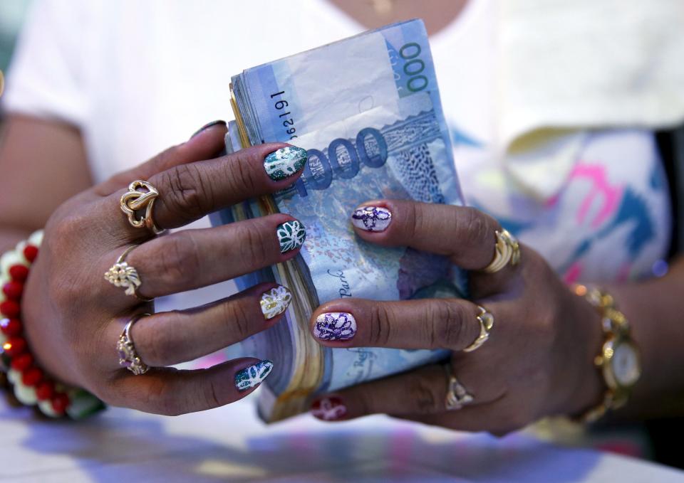 A casino financier wearing rings and with painted fingernails, counts money she collected from a gambler only moments before, in Angeles city, north of Manila, Philippines, May 25, 2015. Financiers normally loan money with high interest rates to gamblers inside casinos. The Philippines has emerged as one of Asia's hottest gambling hubs after it launched its 120-hectare (1.2 square km) gaming and leisure enclave called Entertainment City in the capital, modelled on the Las Vegas strip. When paying your final respects for a relative or friend, the last thing you might expect to see at the wake is people placing bets on a card game or bingo. Not in the Philippines. Filipinos, like many Asians, love their gambling. But making wagers on games such as "sakla", the local version of Spanish tarot cards, is particularly common at wakes because the family of the deceased gets a share of the winnings to help cover funeral expenses. Authorities have sought to regulate betting but illegal games persist, with men and women, rich and poor, betting on anything from cockfighting to the Basque hard-rubber ball game of jai-alai, basketball to spider races. Many told Reuters photographer Erik De Castro that gambling is only an entertaining diversion in a country where two-fifths of the population live on $2 a day. But he found that some gamble every day. Casino security personnel told of customers begging to be banned from the premises, while a financier who lends gamblers money at high interest described the dozens of vehicles and wads of land titles given as collateral by those hoping lady luck would bring them riches. REUTERS/Erik De Castro PICTURE 14 OF 29 FOR WIDER IMAGE STORY "HIGH STAKES IN MANILA". SEARCH "BINGO ERIK" FOR ALL IMAGES. TPX IMAGES OF THE DAY