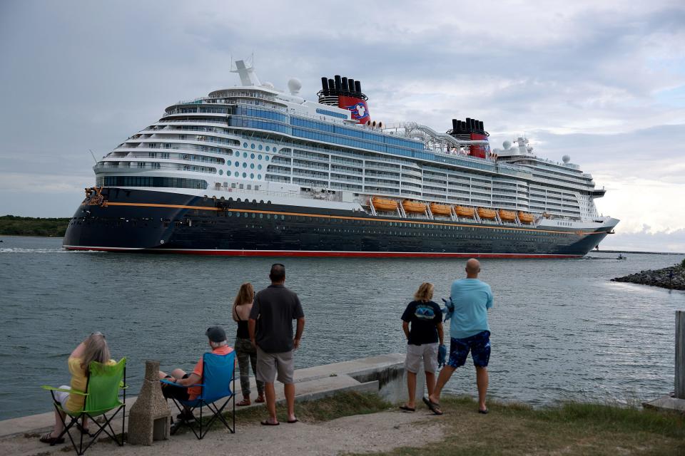 People watch a cruise ship leave Port Canaveral.