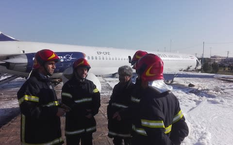 Security forces are seen at the site after an Iranian passenger plane belonging to Caspian Airlines skidded off the runway near the airport in the southern city Mahshahr, Tehran - Credit: Anadolu