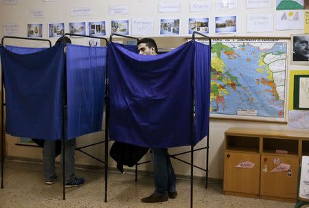 A man casts his vote in a booth during the Greek parliamentary elections in Athens, January 25, 2015. REUTERS/Alkis Konstantinidis