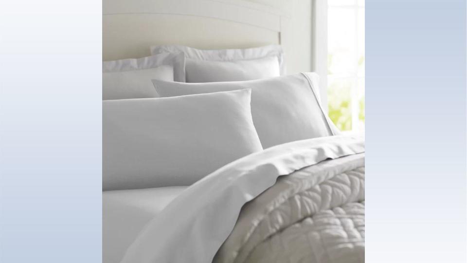 The wayfair sheets on a bed with pillows and a comforter. 