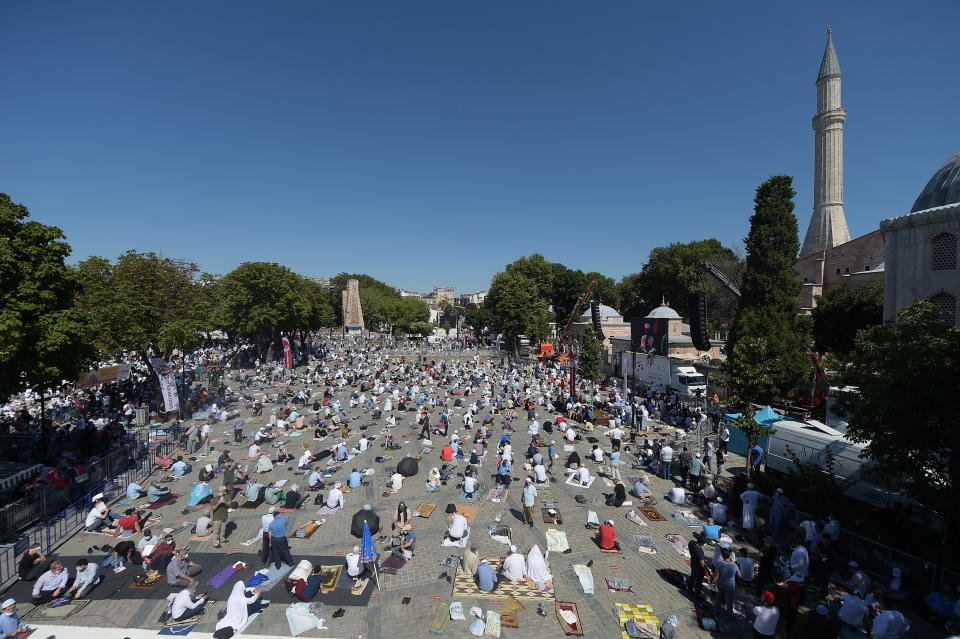 Faithful wait at the historic Sultanahmet district of Istanbul, near the Byzantine-era Hagia Sophia, Friday, July 24, 2020. Hundreds of Muslim faithful were making their way to Istanbul's landmark monument Friday to take part in the first prayers in 86 years at the structure that was once Christendom's most significant cathedral and the "jewel" of the Byzantine Empire then a mosque and museum before its re-conversion into a Muslim place of worship. The conversion of the edifice, has led to an international outcry. (AP Photo/Yasin Akgul)