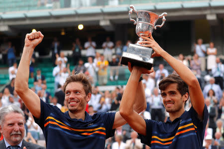 Tennis - French Open - Roland Garros, Paris, France - June 9, 2018 France's Pierre-Hugues Herbert (R) and Nicolas Mahut celebrate with the trophy after winning the men's doubles final against Austria's Oliver Marach and Croatia's Mate Pavic REUTERS/Gonzalo Fuentes