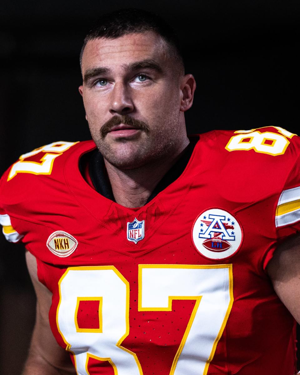 A mustache softens Kelce’s young-jock look.