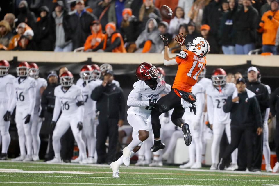 Oct 28, 2023; Stillwater, Oklahoma, USA; Oklahoma State Cowboys wide receiver Leon Johnson III (17) catches a pass beside Cincinnati Bearcats cornerback Justin Harris (12) during a college football game between Oklahoma State and Cincinnati at Boone Pickens Stadium. Oklahoma State won 45-13. Mandatory Credit: Bryan Terry-USA TODAY Sports