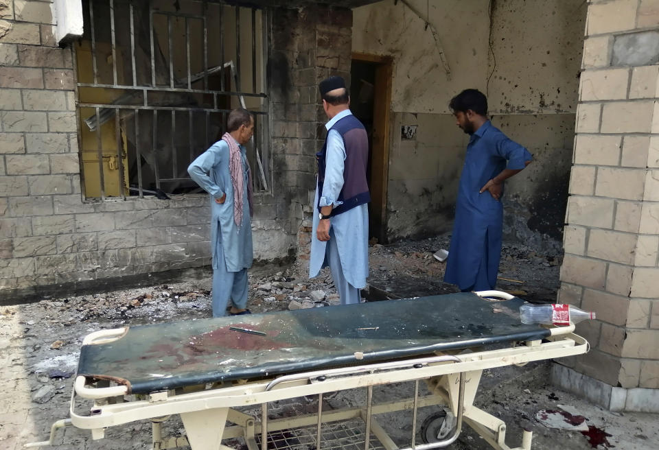 Hospital staff gather at the site of a bombing on an entrance of a hospital in Dera Ismail Khan, Pakistan, Sunday, July 21, 2019. Police in Pakistan say gunmen opened fire on a police post and then bombed the entrance to a hospital as the wounded were being brought in. (AP Photo/Ishtiaq Mahsud)