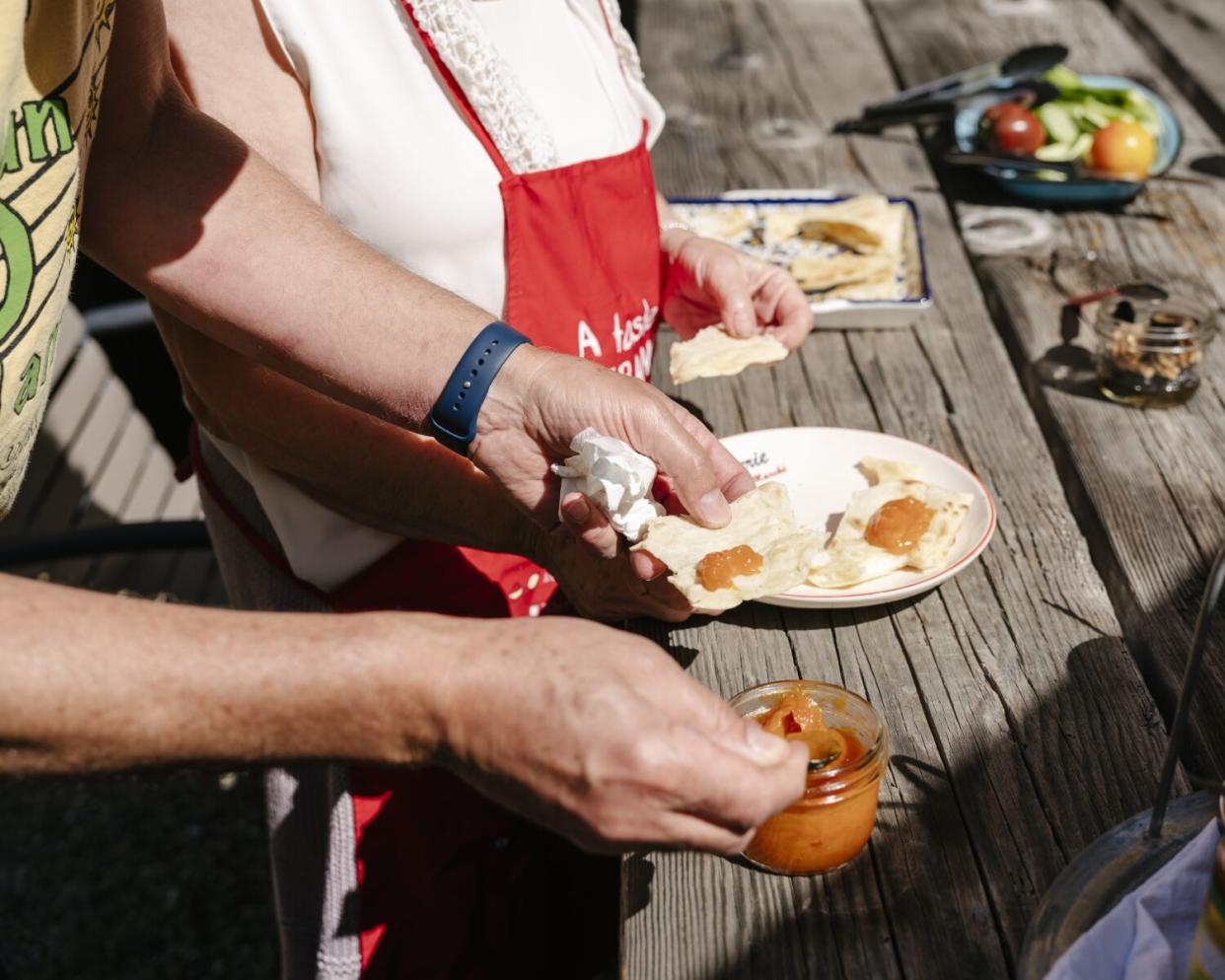 Amer Budayr puts apricot jam he made on maneesh at his home.