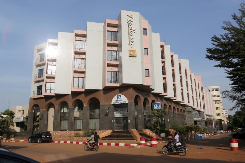 FILE PHOTO: People drive motorcycles past the Radisson Blu hotel in Bamako