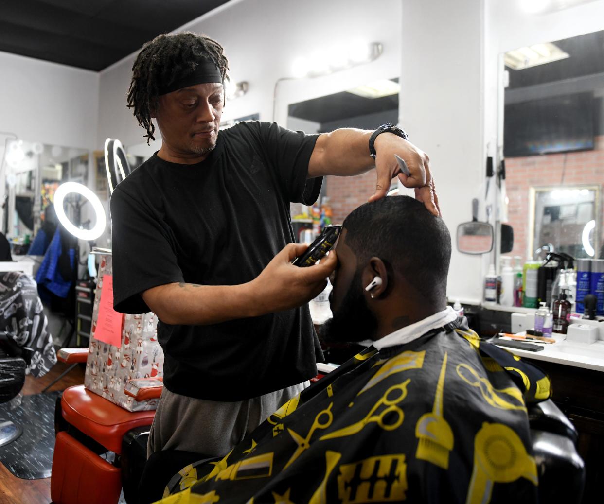Mike Cundiff styles T.J. Jackson Jr. of Massillon at Mr C's Mastery Cutting Barber Shop in downtown Canton.
