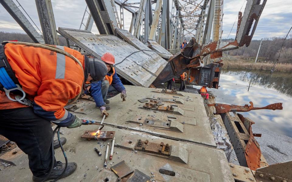 Workers repair a railway bridge after it was damaged in fighting between the Ukrainian and Russian armies in the town of Kupiansk - SERGIY KOZLOV/EPA-EFE/Shutterstock/Shutterstock