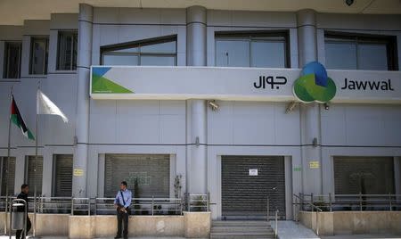 Palestinian policemen loyal to Hamas stand guard outside the closed Jawwal company headquarters in Gaza City June 30, 2015. REUTERS/Mohammed Salem