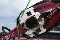 Track workers remove the car of Alfa Romeo driver Guanyu Zhou of China after a crash at the start of the British Formula One Grand Prix at the Silverstone circuit, in Silverstone, England, Sunday, July 3, 2022. (AP Photo/Frank Augstein)