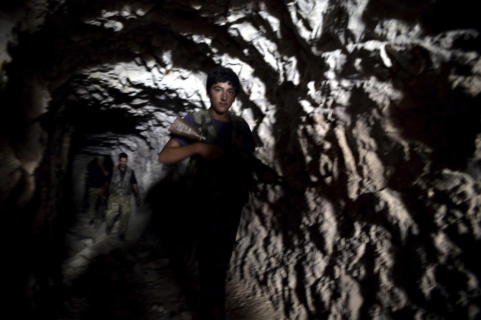 FILE -- In this Sunday, Sept. 9, 2018 file photo, fighters with the Free Syrian army leave a cave where they live, in the outskirts of the northern town of Jisr al-Shughur, Syria, west of the city of Idlib. Turkey and Russia appear to have succeeded in creating a demilitarized zone along the frontlines of Syria's flashpoint Idlib region, after rebels and an al-Qaida-linked alliance pulled back their heavy weaponry in accordance with the agreement. (Ugur Can/DHA via AP, File)