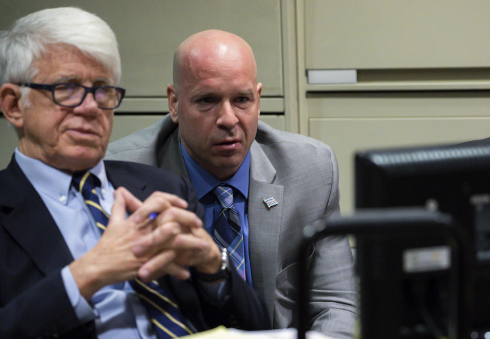 In this Wednesday, Nov. 28, 2018 photo, attorney Thomas Breen, left, watches dash-cam video introduced by prosecutors with his client former Officer Joseph Walsh projected by the prosecution team during the trial of Chicago police Officer Thomas Gaffney, former Detective David March and Walsh during a bench trial before Judge Domenica A. Stephenson at Leighton Criminal Court Building in Chicago. The three Chicago police officers are charged with lying to protect Jason Van Dyke, a fellow officer from criminal prosecution after he fatally shot black teenager Laquan McDonald in 2014. (Zbigniew Bzdak/Chicago Tribune via AP, Pool)