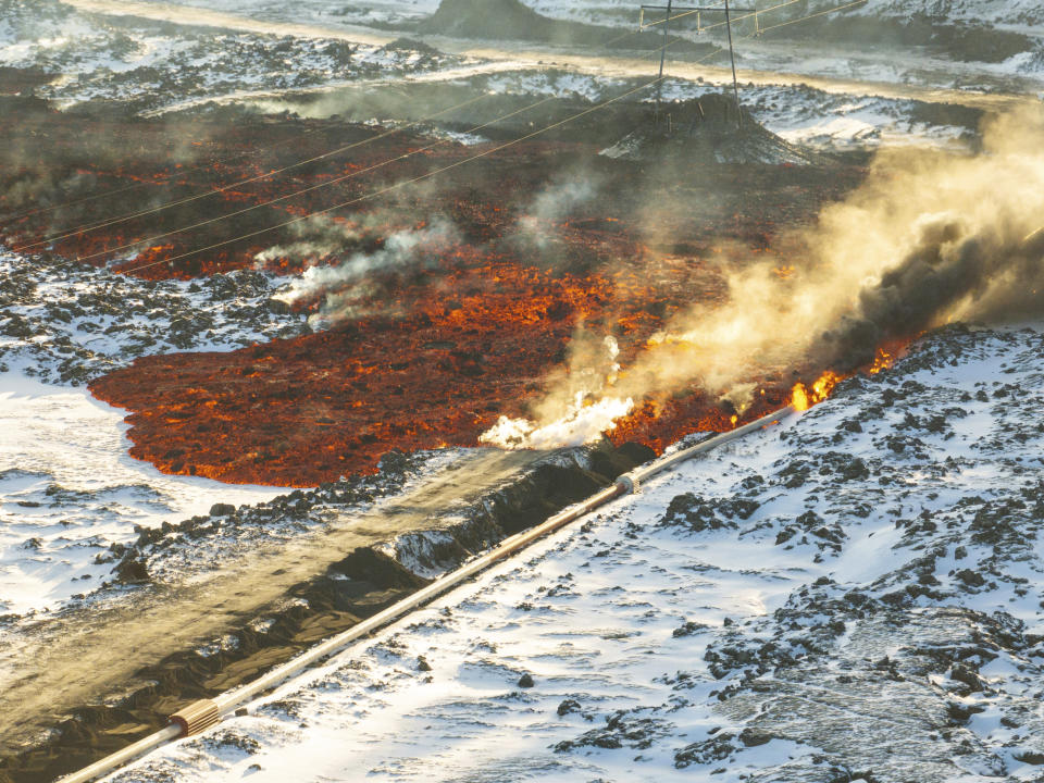 A view of lava hitting the hot water pipeline flowing on the road leading to the Blue Lagoon, in Grindavík, Iceland, Thursday, Feb. 8, 2024. A volcano in southwestern Iceland has erupted for the third time since December and sent jets of lava into the sky. The eruption on Thursday morning triggered the evacuation the Blue Lagoon spa which is one of the island nation’s biggest tourist attractions. (AP Photo /Marco Di Marco)