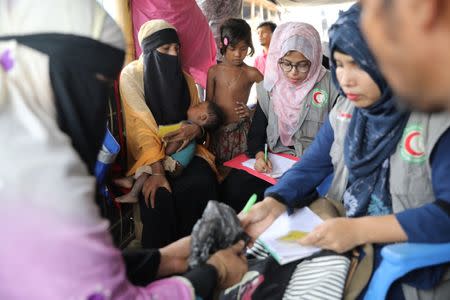 Members of Bangladesh Red Crescent Society collect trace message requests from Rohingya refugees who have missing relatives in Myanmar or other countries, at a camp in Cox's Bazar, Bangladesh, July 3, 2018. Picture taken July 3, 2018. REUTERS/Mohammad Ponir Hossain