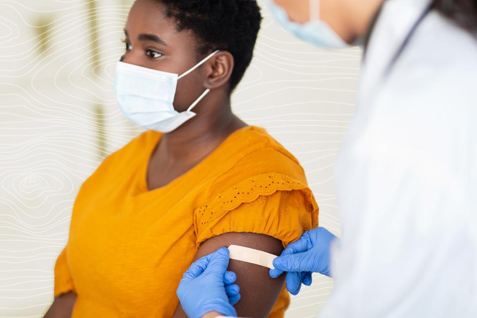 Lady Getting Vaccinated While Doctor Applying bandaid After Injection Indoors