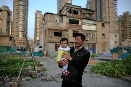 Yueyue is held by her grandfather in an empty area outside their house at Guangfuli neighbourhood, in Shanghai, China, April 1, 2016. REUTERS/Aly Song