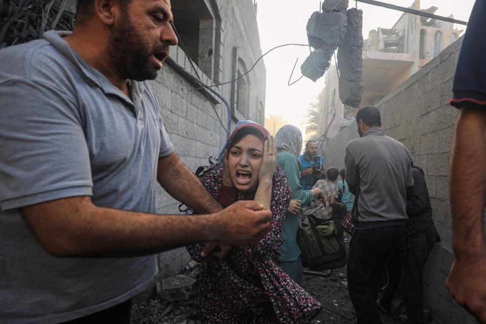 People flee following Israeli air strikes on a neighbourhood in the al-Maghazi refugee camp in the central Gaza Strip  on 6 November (AFP via Getty Images)