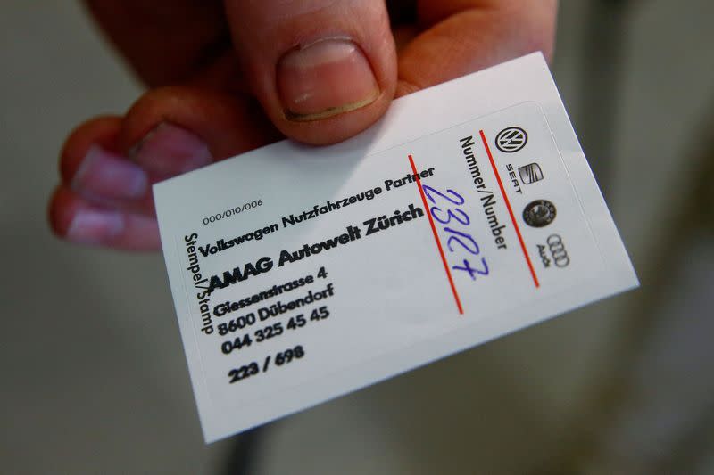 FILE PHOTO: Employee Portmann displays a seal of approval after installing new software at a diesel powered VW Amarok car at a garage of Swiss AMAG in Duebendorf