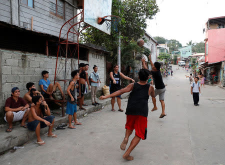 Residents play basketball along a street in Barangay Payatas district in Quezon City, Metro Manila in the Philippines December 11, 2017. REUTERS/Erik De Castro