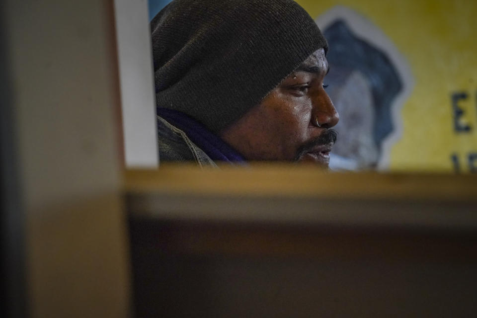 Painter Guy Stanley Philoche, a 43-year-old Haitian immigrant and star in the New York art world, sit among work during an interview at his East Harlem studio, Thursday Nov. 19, 2020, in New York. After a hugely successful gallery show, Philoche wanted to treat himself to a fancy $15,000 watch, instead he bought the works of fellow artists struggling in the pandemic. "I'm not a rich man," he said, "but I owe a big debt to the art world." (AP Photo/Bebeto Matthews)