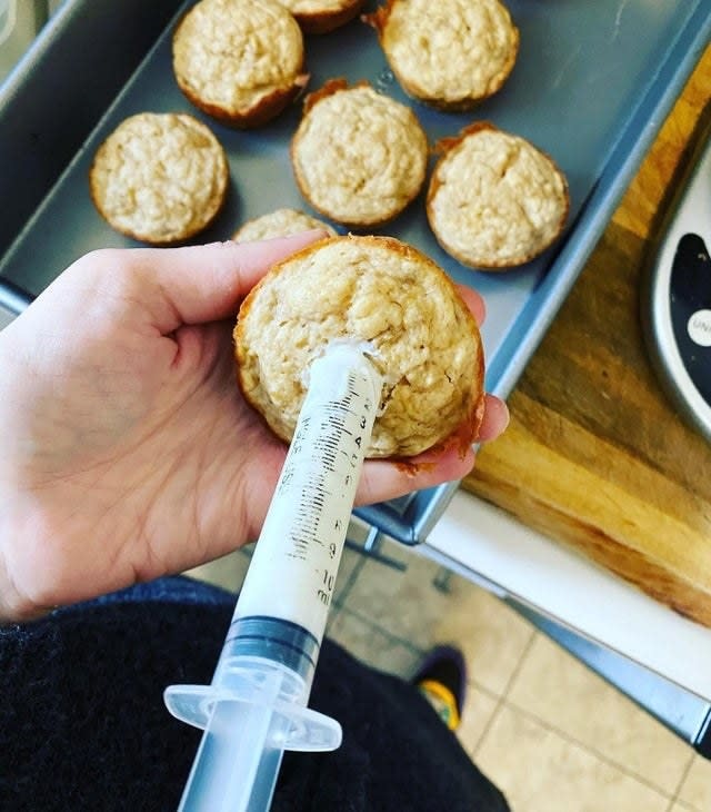 Filling muffins with a syringe.