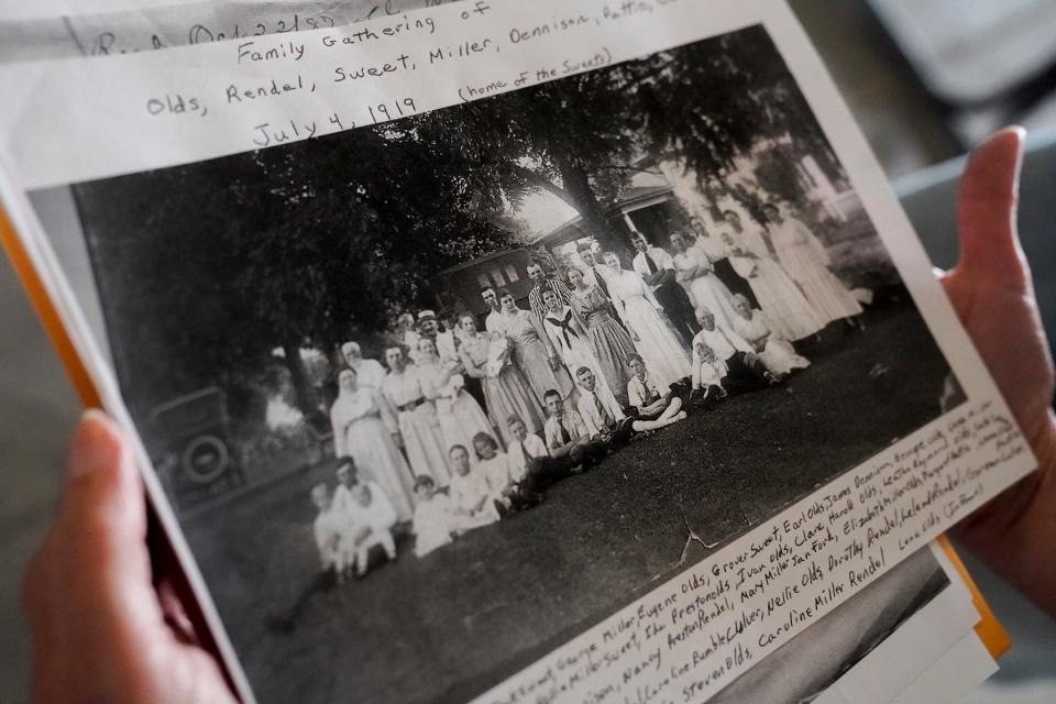 Jen Reum, 51, of Holt, holds a photograph from a Rendel family reunion in 1919 during the 115th annual Rendel Family Reunion in Milan on July 30, 2023.